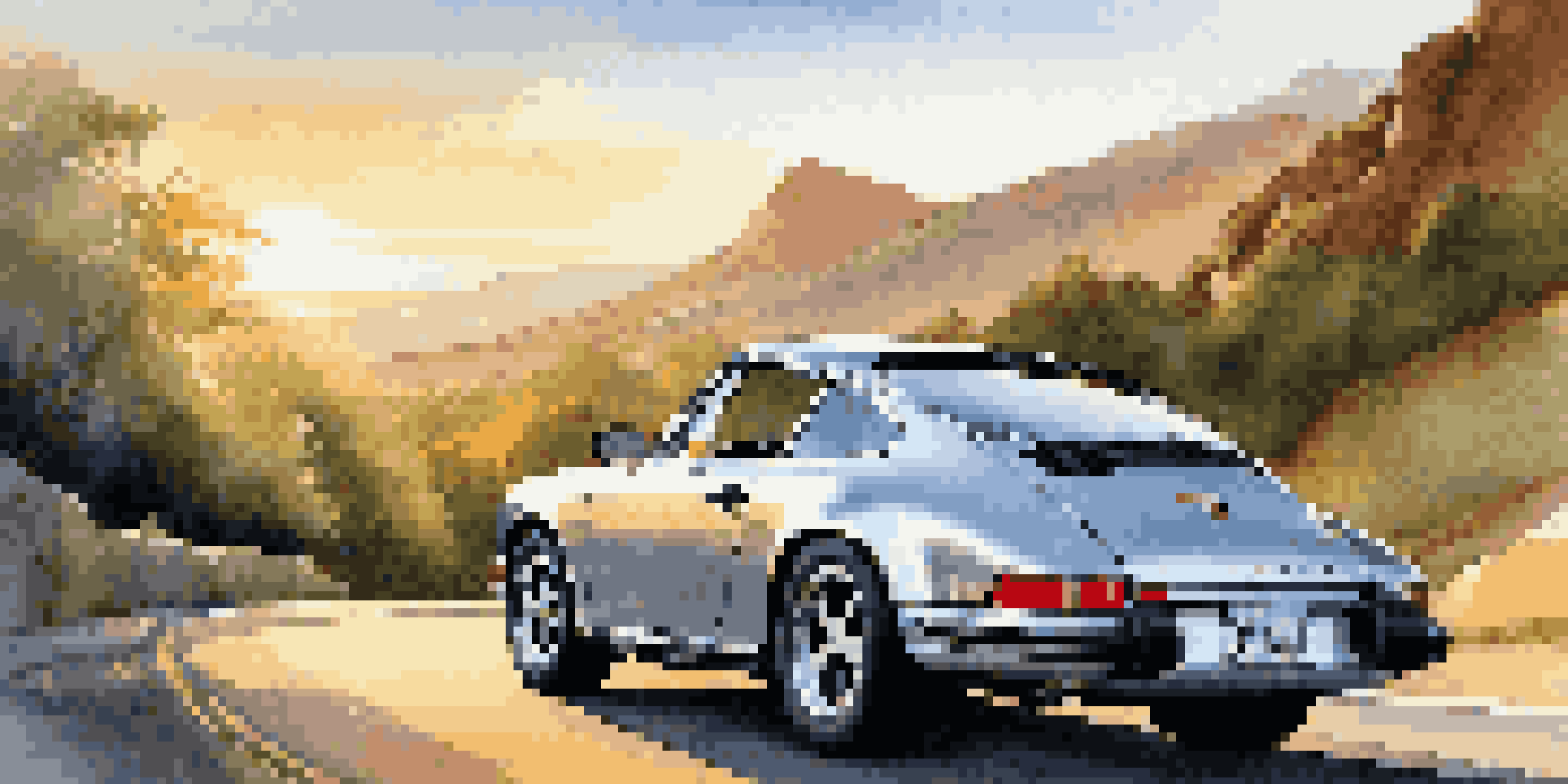 A silver Porsche 911 parked on a scenic mountain road during sunset, surrounded by greenery.