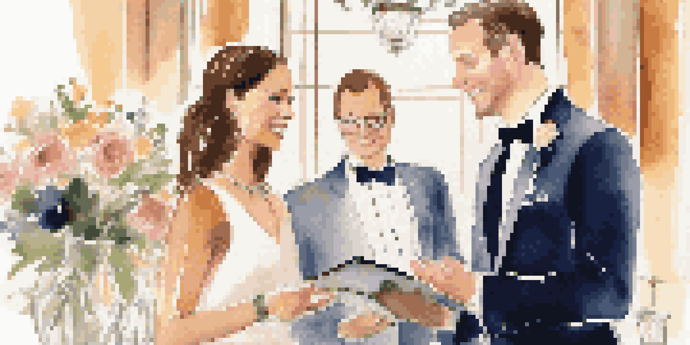 An event planner talks with a couple in a beautifully decorated venue, surrounded by flowers and soft lighting.