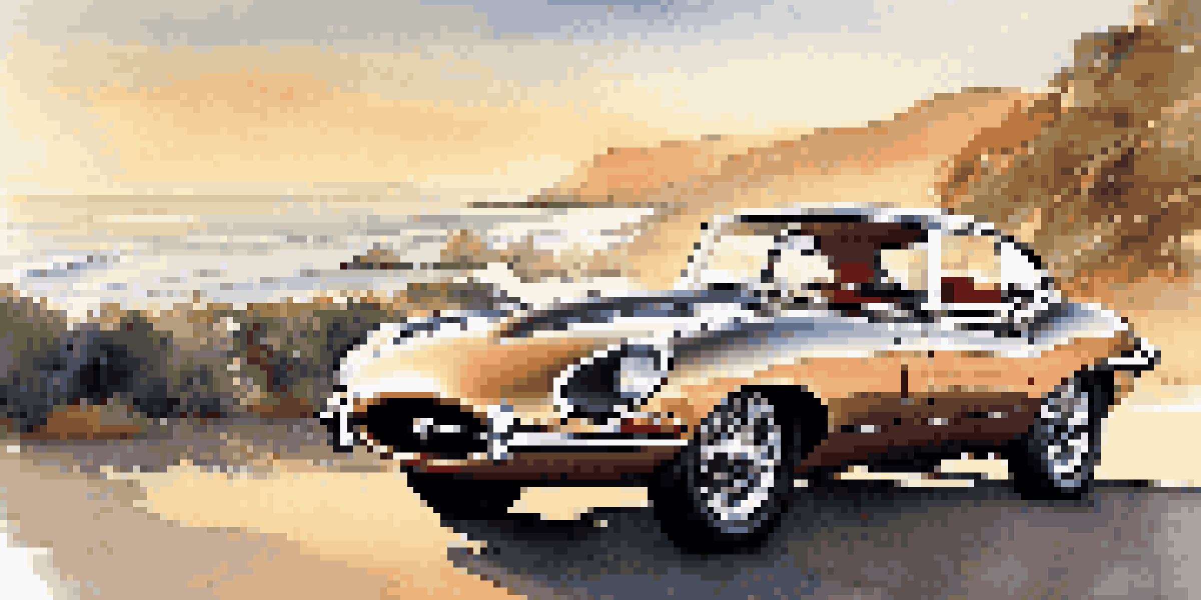 A vintage 1961 Jaguar E-Type parked near the coast during sunset, showcasing its elegant design and the surrounding ocean scenery.