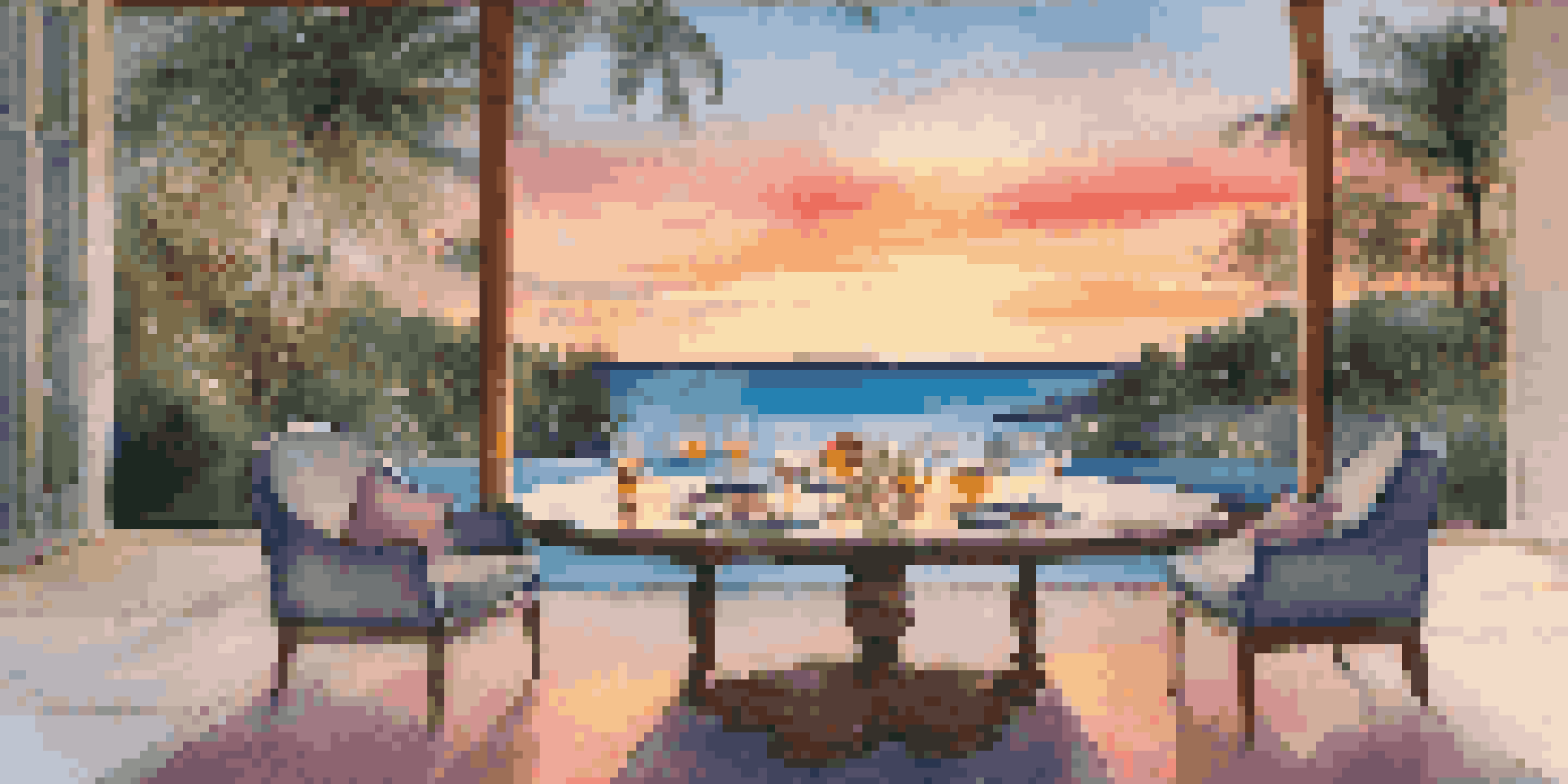A tranquil sunset scene featuring a private infinity pool reflecting vibrant colors, surrounded by palm trees and a gourmet dining setup.