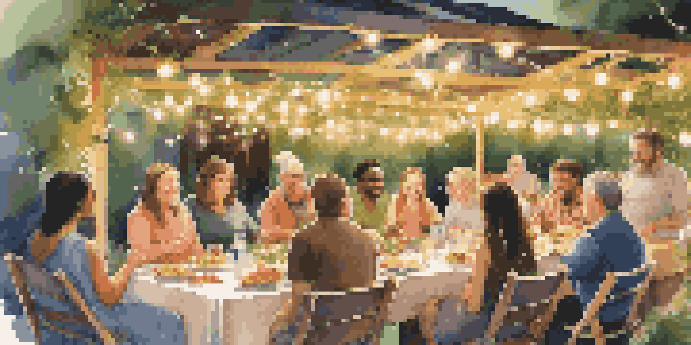A community dinner in a garden with guests enjoying food under fairy lights.
