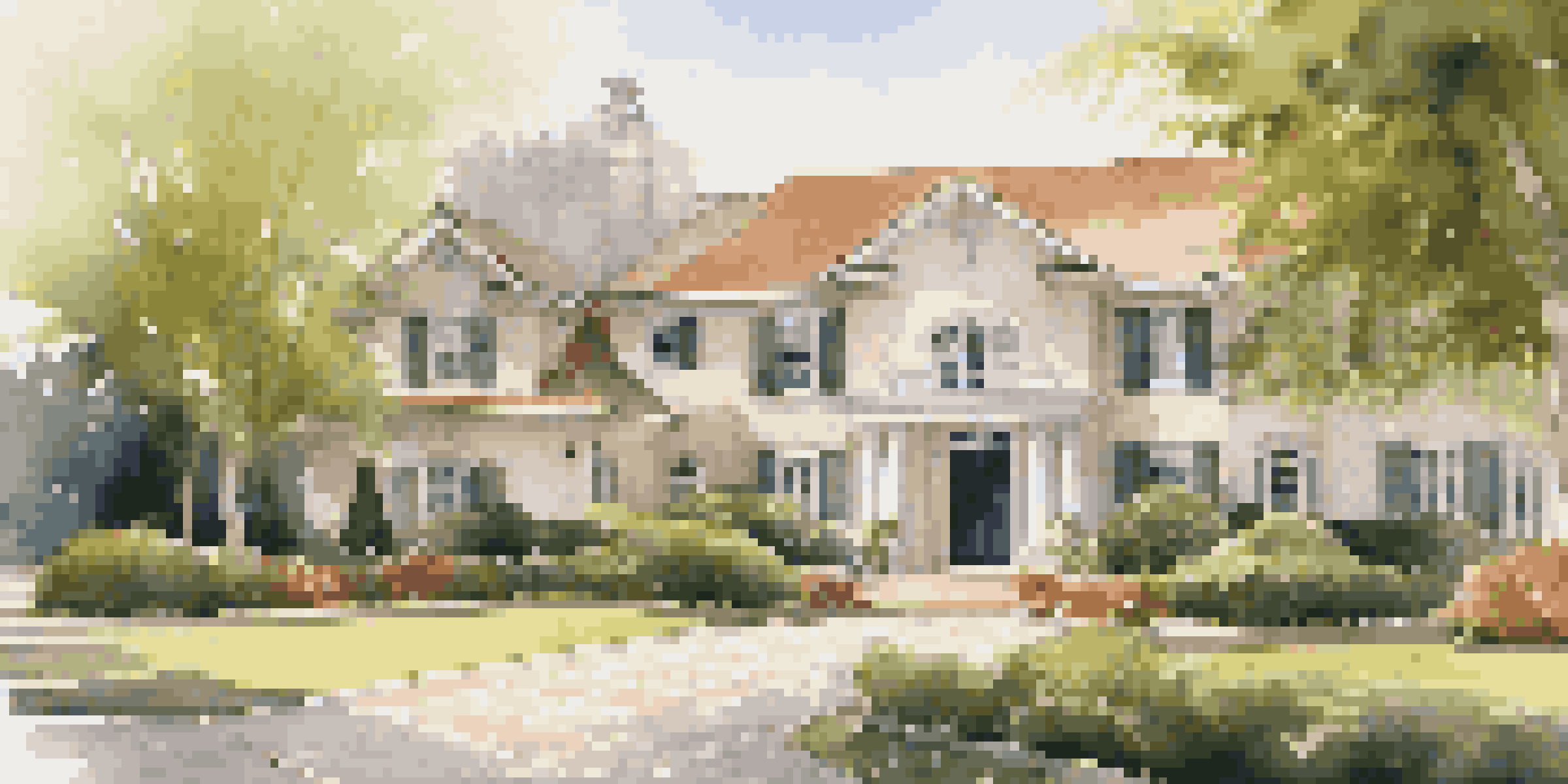 A well-maintained luxury home with a clean driveway and lush greenery under soft sunlight.