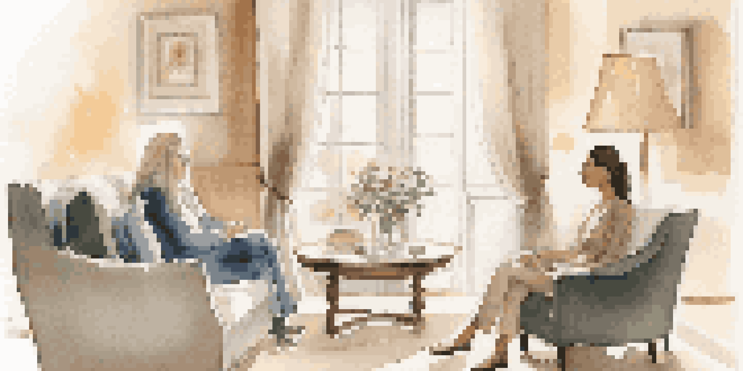 A luxury relationship coach and a client engaged in a conversation in a cozy, well-lit room, surrounded by soft colors and plush seating.