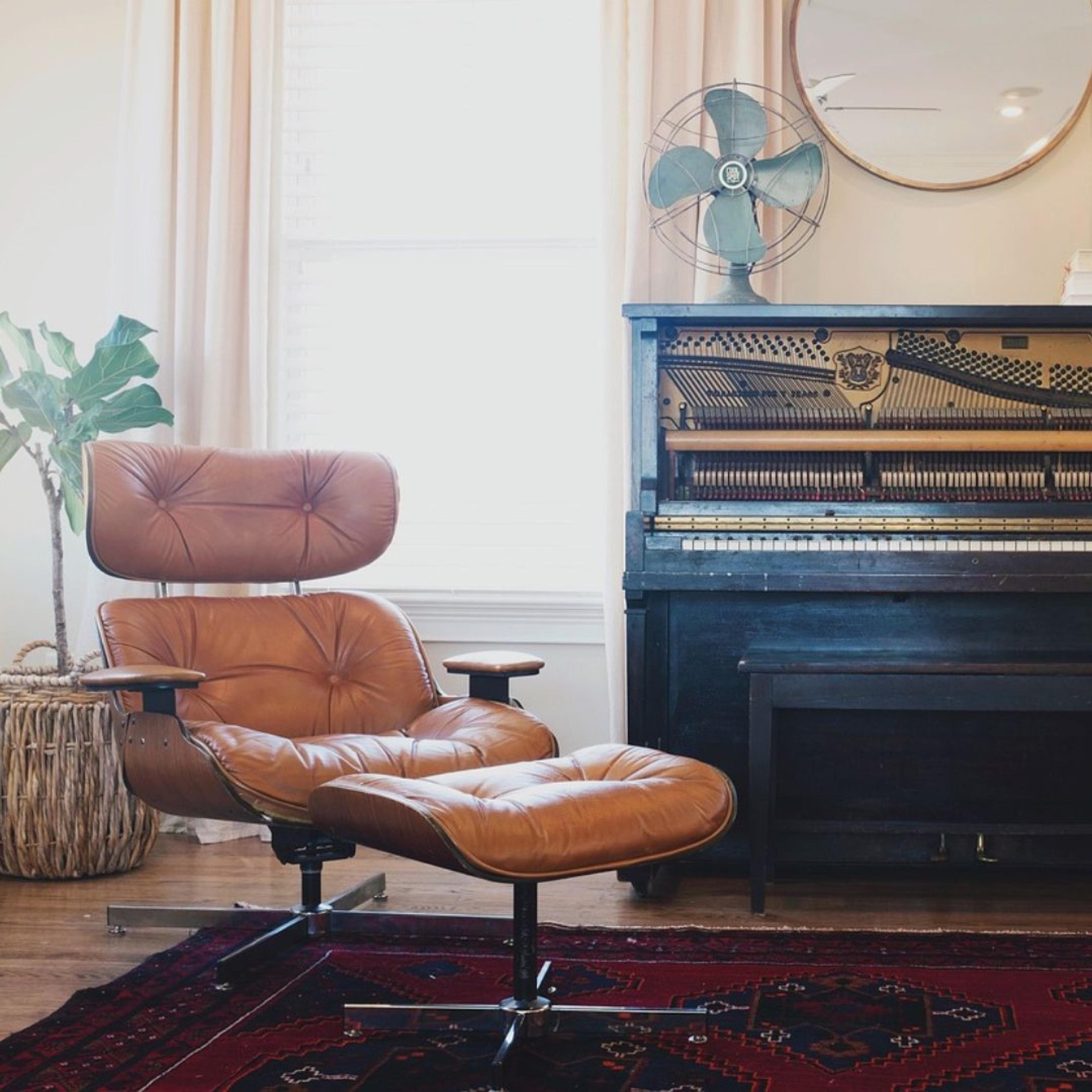 A calm therapy room with a leather armchair, footstool and piano