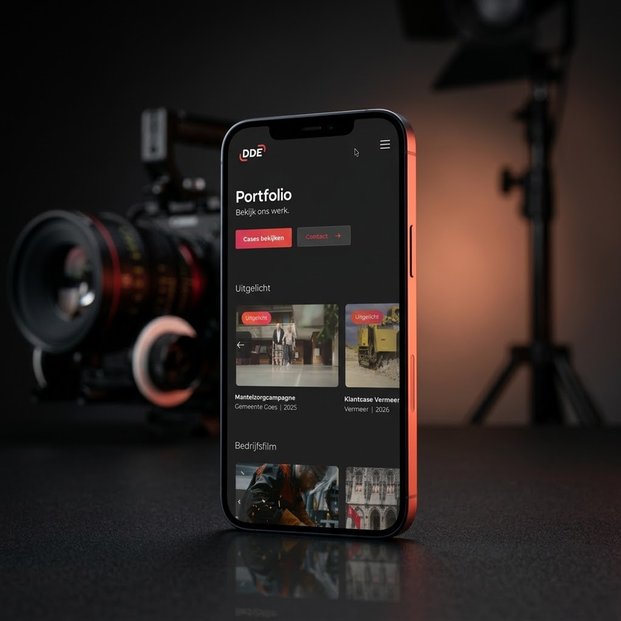 Website van DDE op een telefoon naast een camera