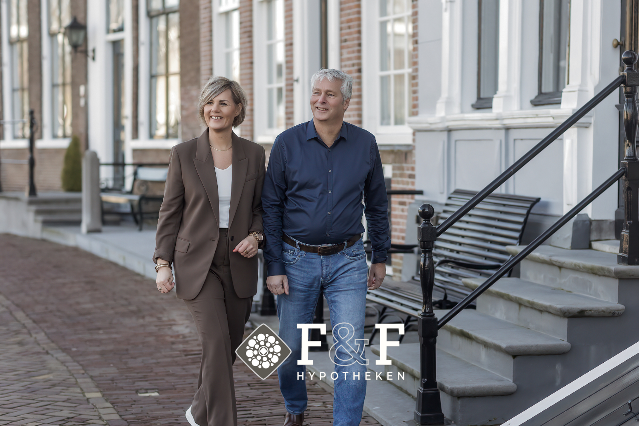 Een vrouw en een man lopen in de stad, met het Faasse en Fermont hypotheken logo