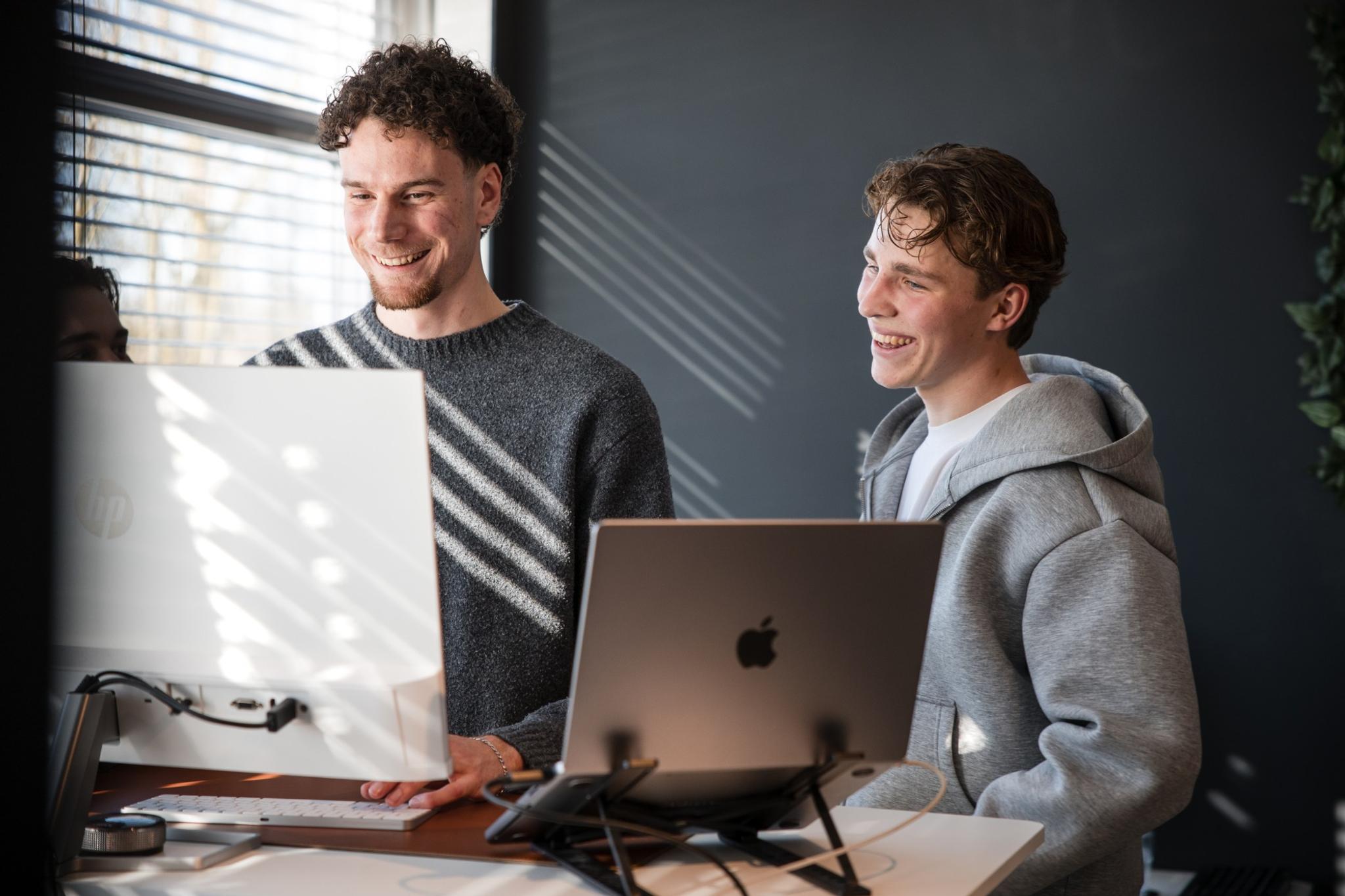 Twee collega's samen aan het werk achter een scherm