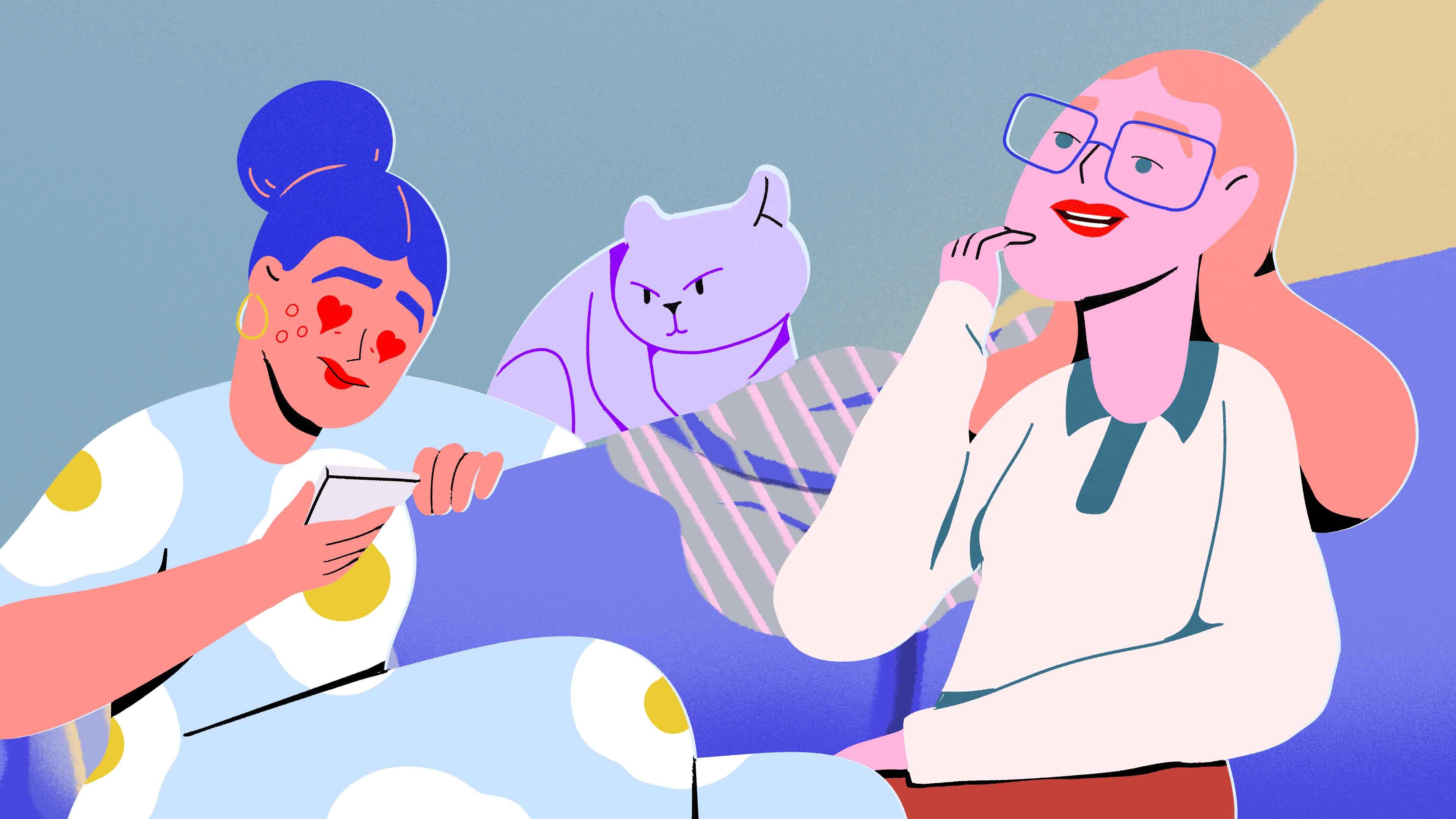 Two women sitting on a couch with a cat