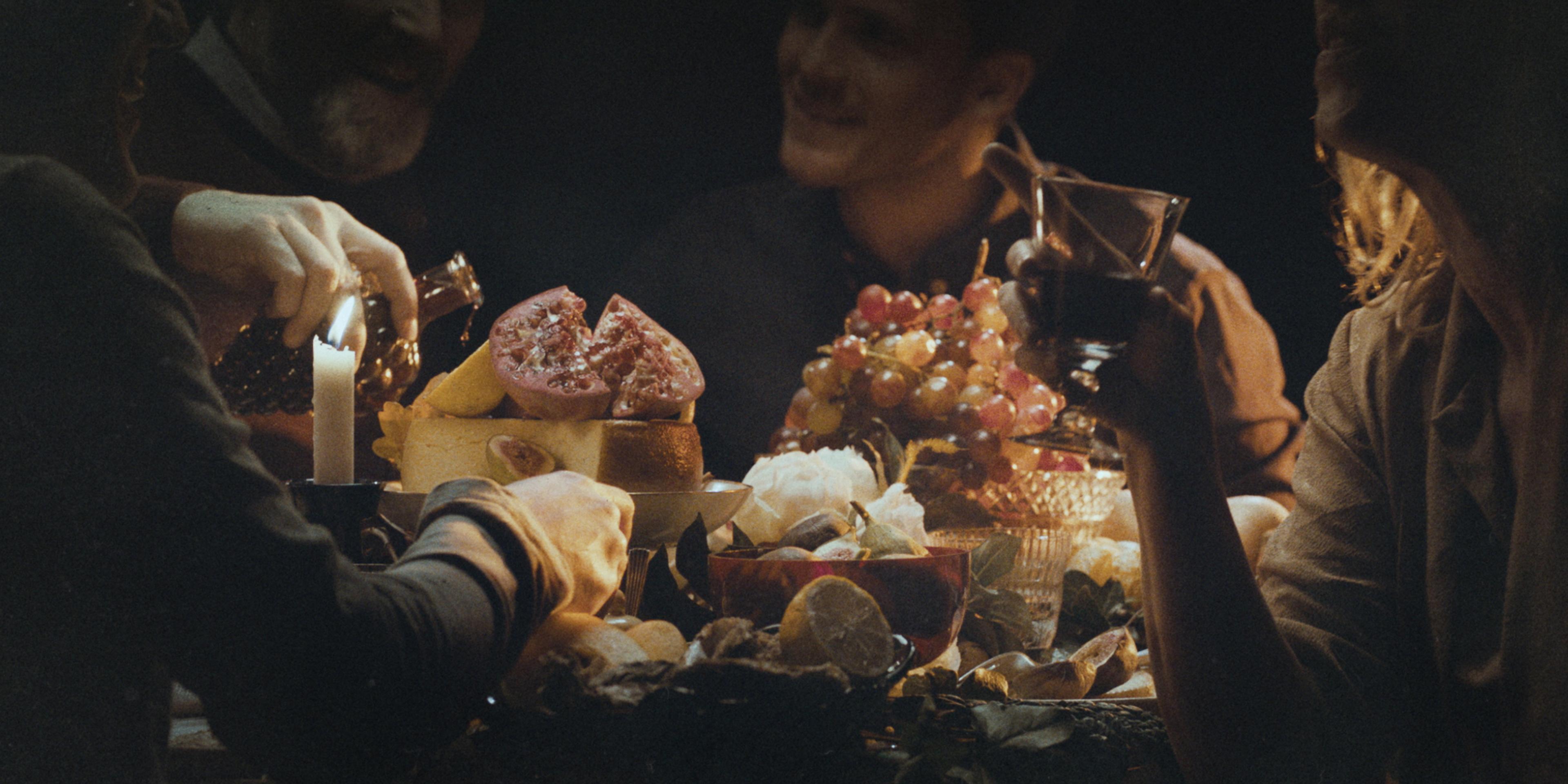 people eating and drinking together in a dimly lit room