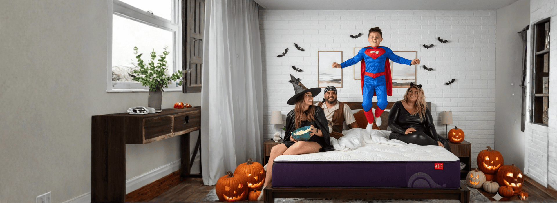 Family as a witch, pirate, superman and a cat in a halloween bedroom on their Big Fig mattress
