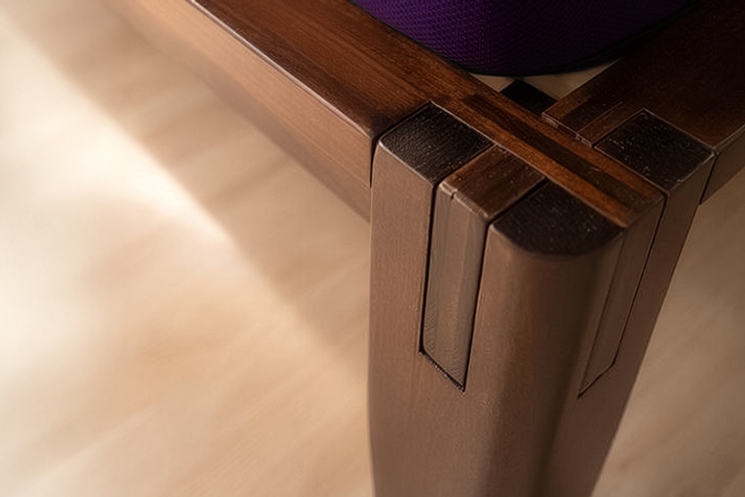 Close-up of a wooden platform bed leg with Japanese-style joint on a light wood floor.