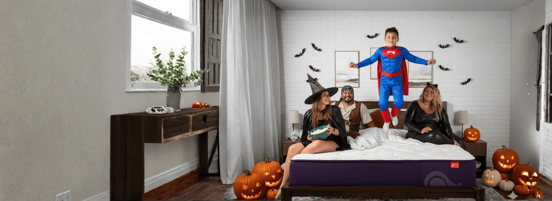 Family as a witch, pirate, superman and a cat in a halloween bedroom on their Big Fig mattress