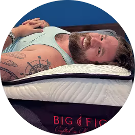 Zach Miko smiling to camera on his back on his Big Fig Luxe mattress