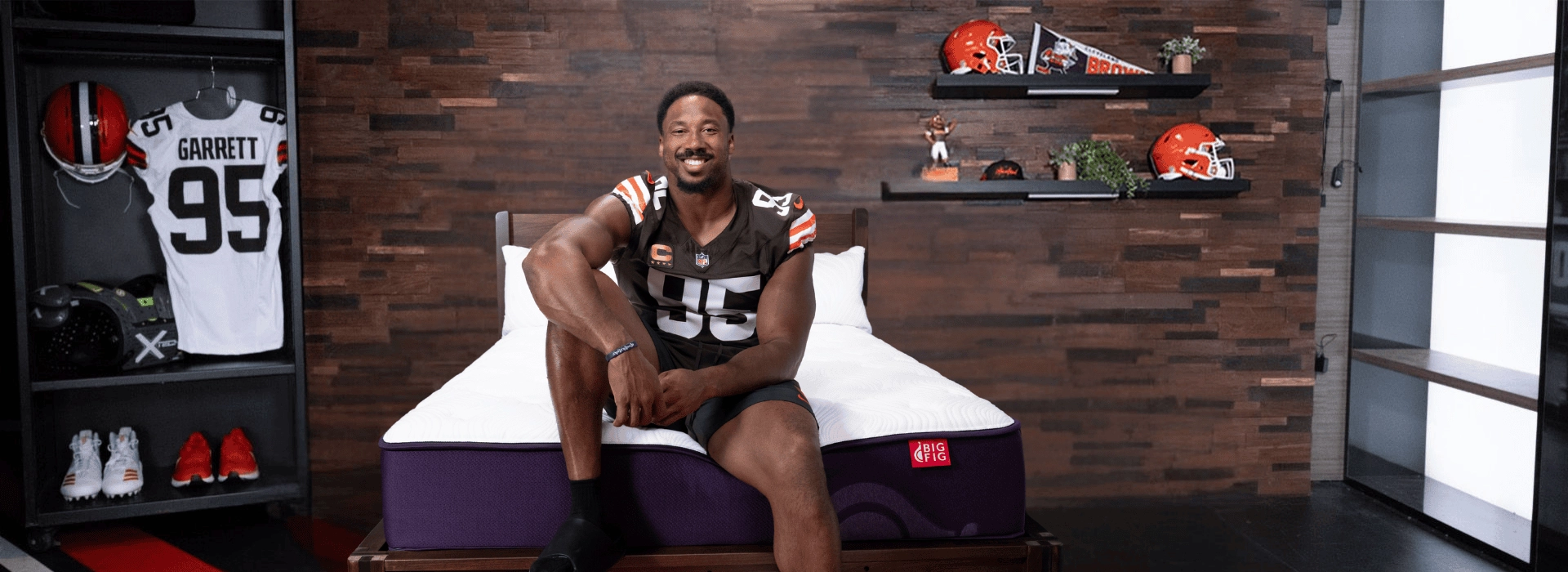 Myles Garrett with his leg up posing on a Big Fig Mattress in a locker room setting