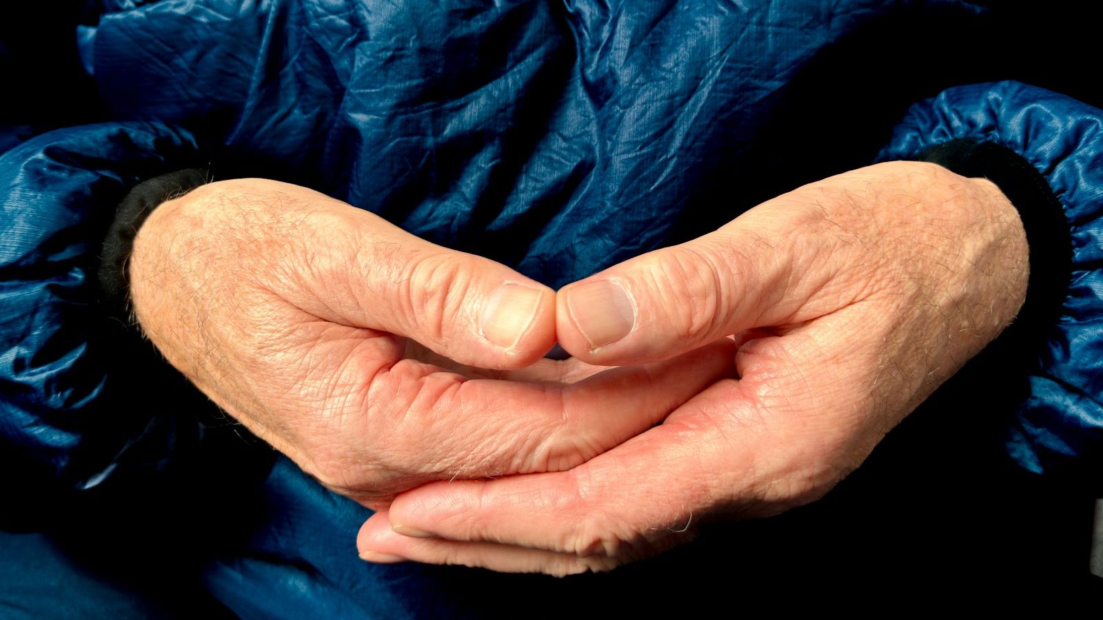 Hands are clasped together, forming a heart shape.