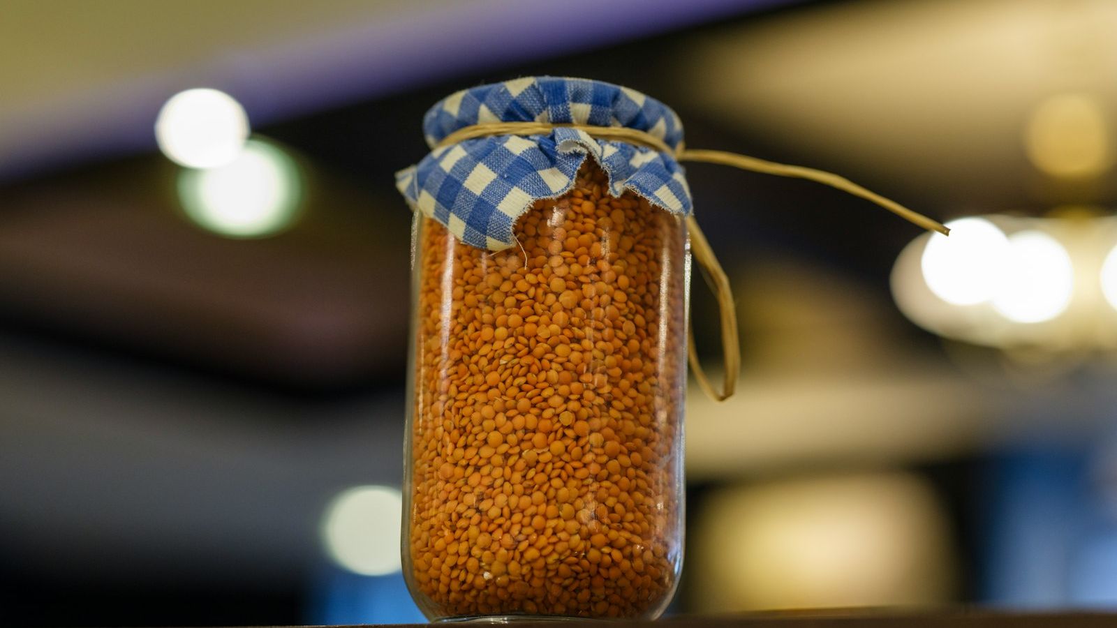 Jar of lentils with a fabric cover.
