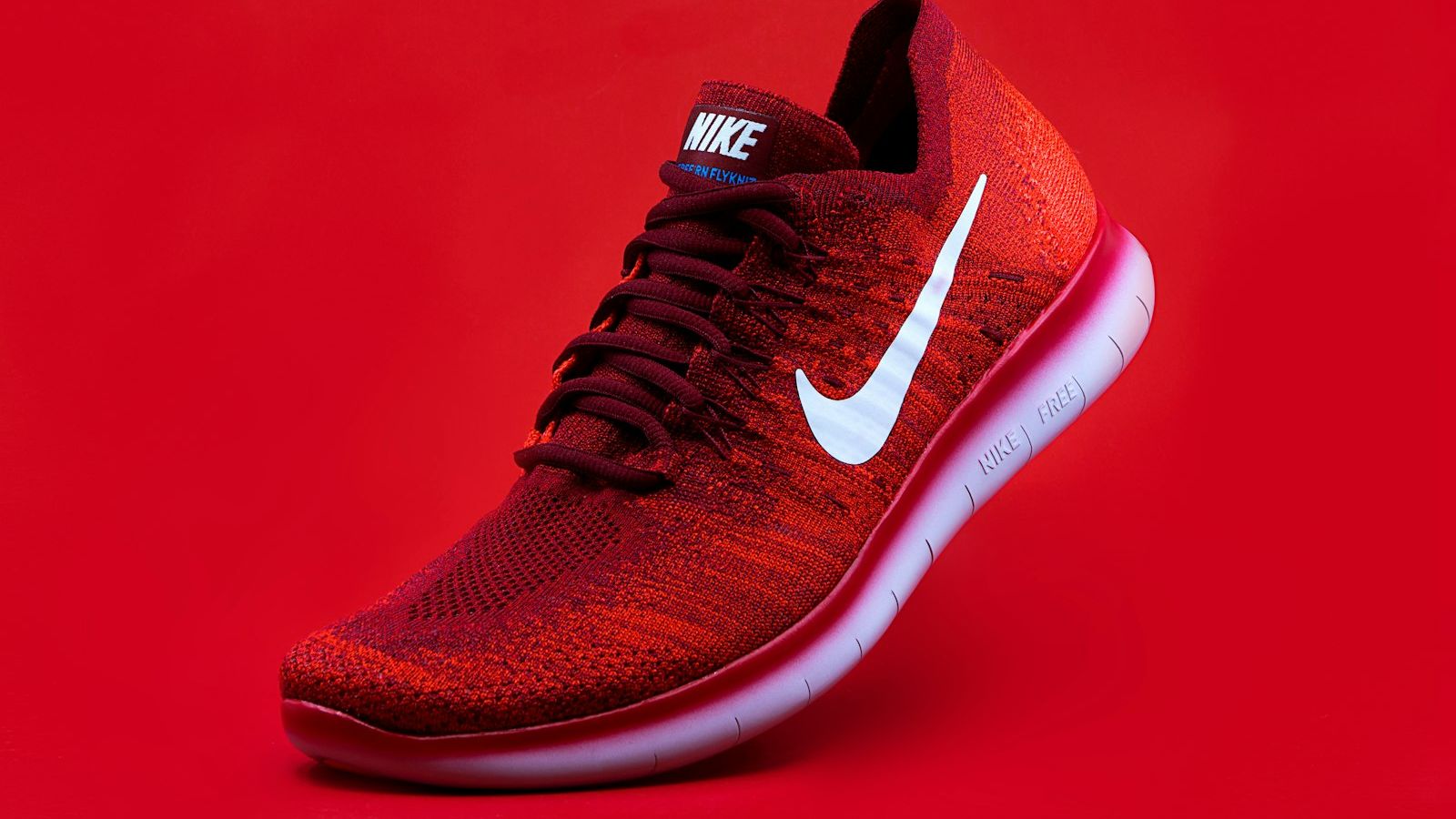 unpaired red Nike sneaker