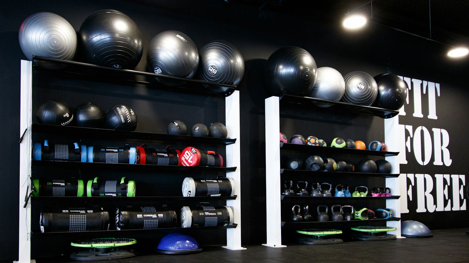 a gym with a wall full of exercise balls