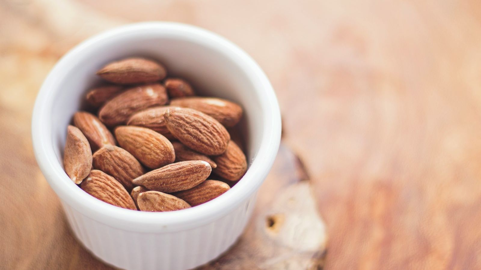 shallow focus photography of almonds in white ceramic bowl