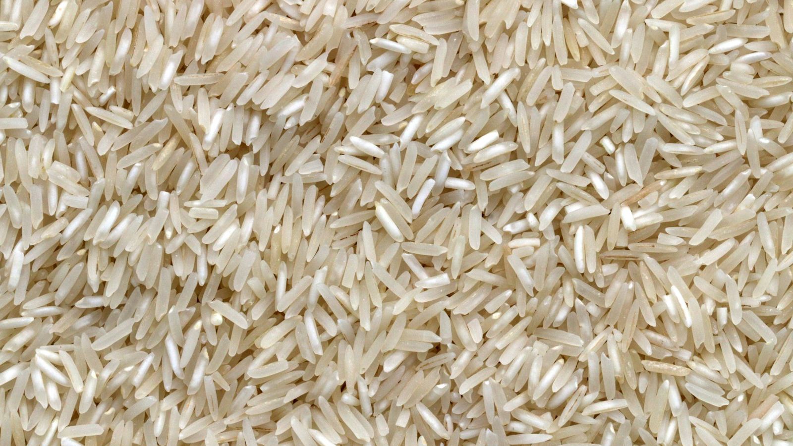 white rice grains on brown wooden table
