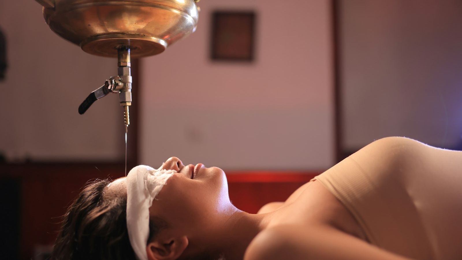 Woman receiving oil treatment on her forehead