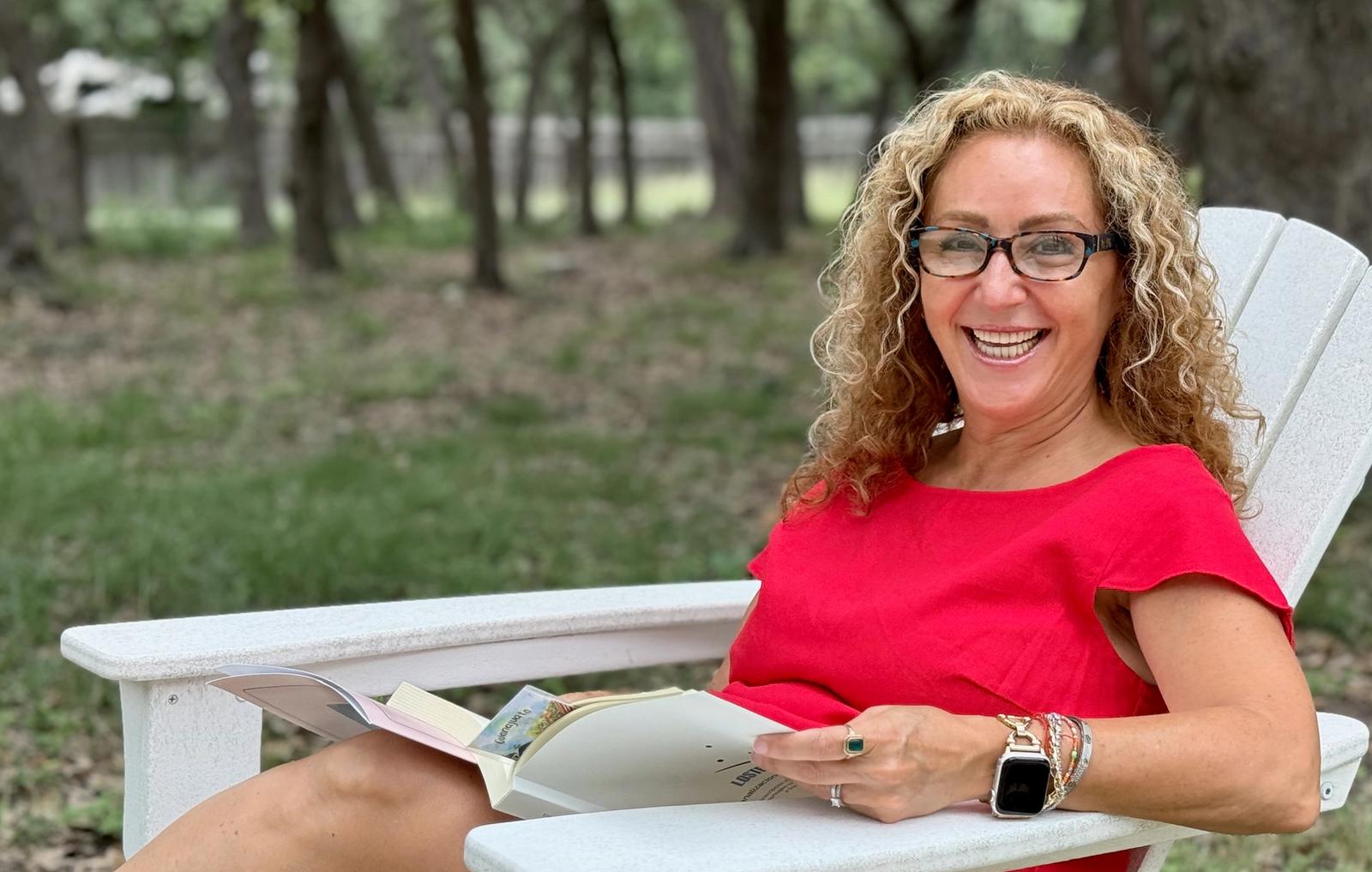 Claudia smiling on a porch with a cup of coffee