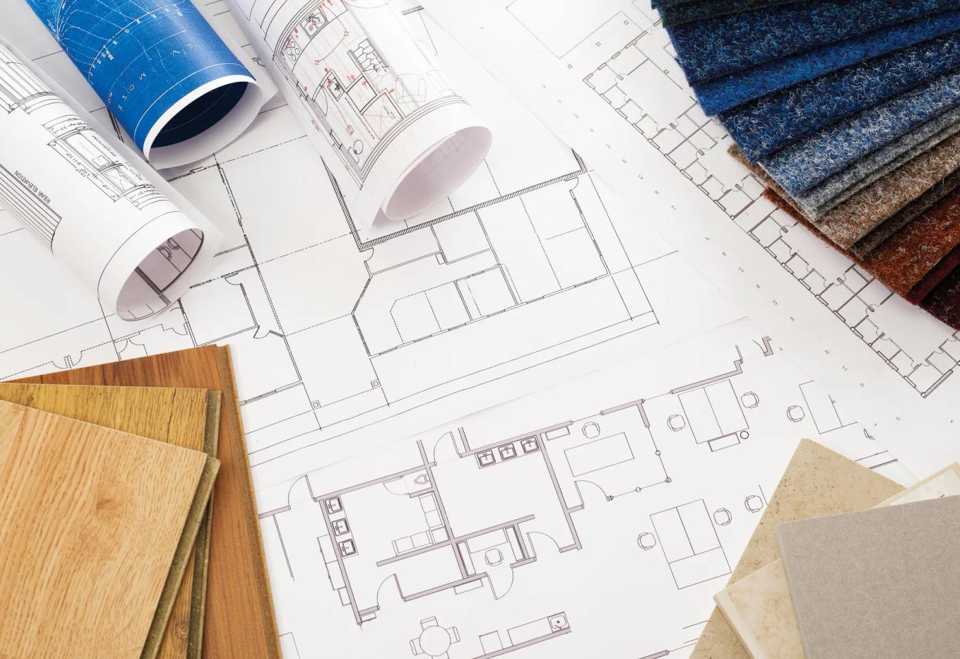 Architectural floor plans with wood, stone, and fabric samples arranged for home design selections.
