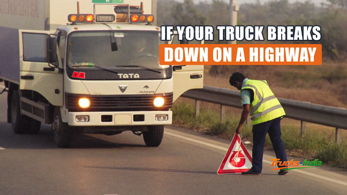 Truck stopped on the shoulder of an Indian highway with warning triangle placed behind it