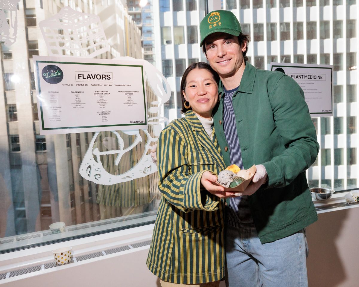A photo of Laz and his wife. They're both smiling and hugging and both holding a tray of Laz's Ice Cream containing scoops of all the flavors.
