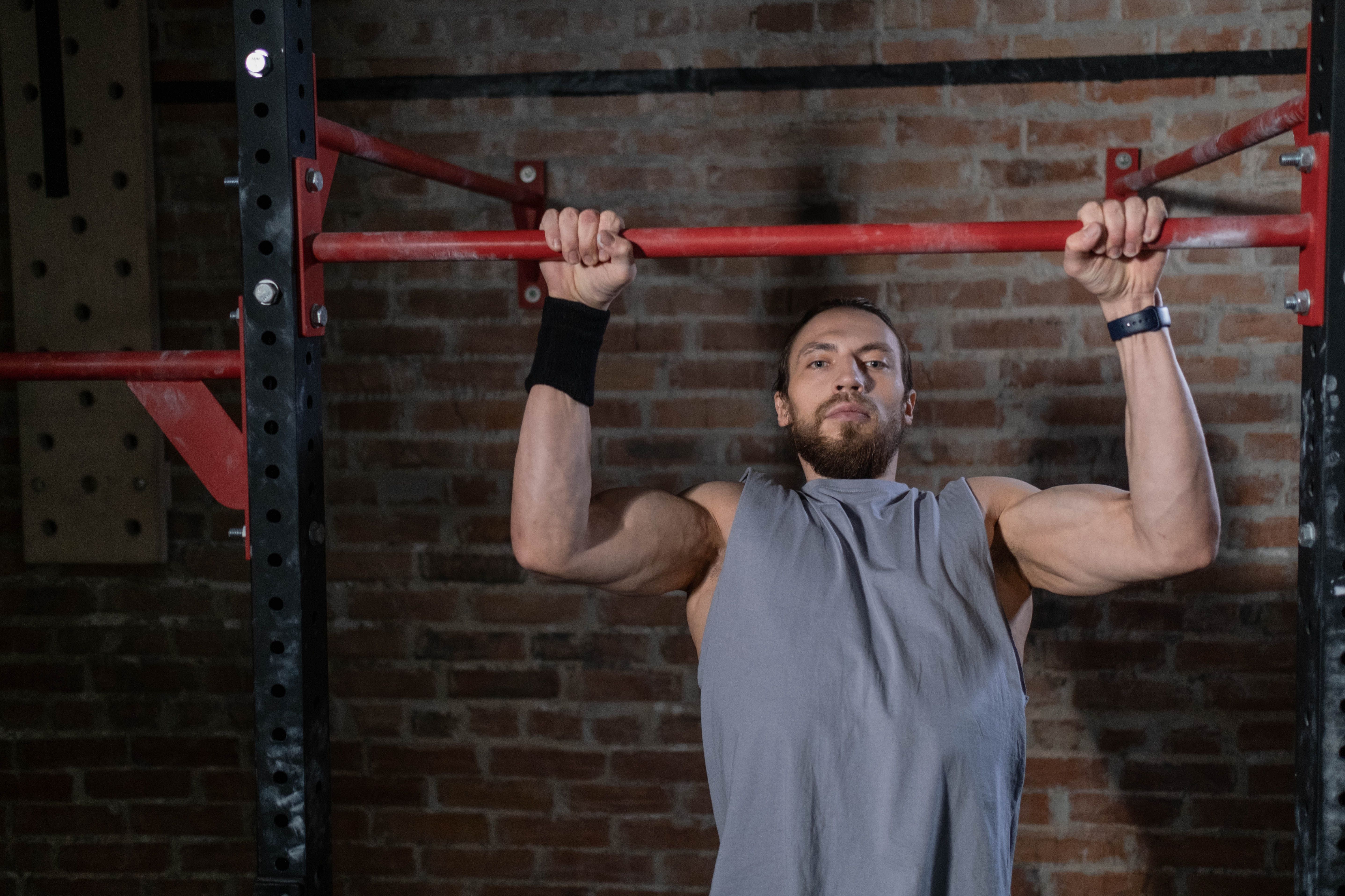 Man in grey shirt performs pull-up
