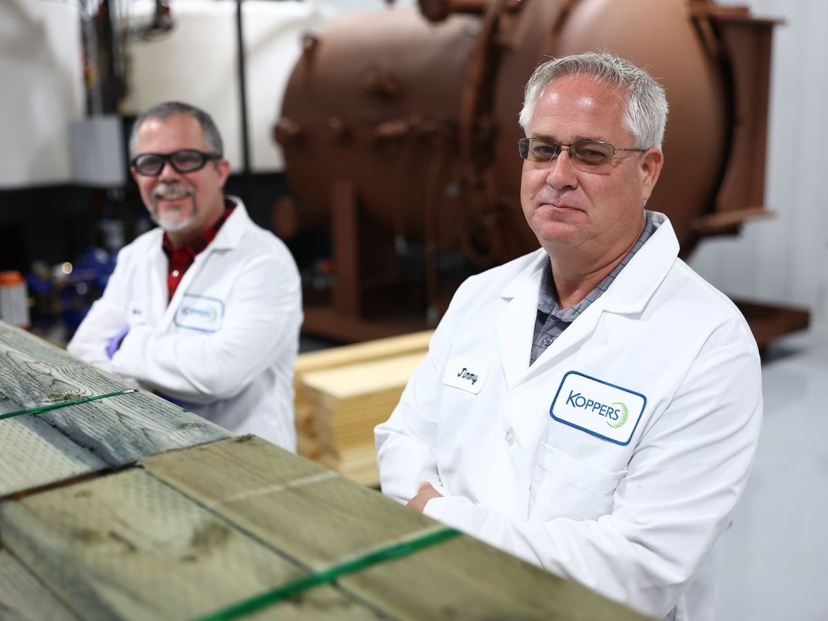 Staff beside a treatment cylinder at the Geelong plant
