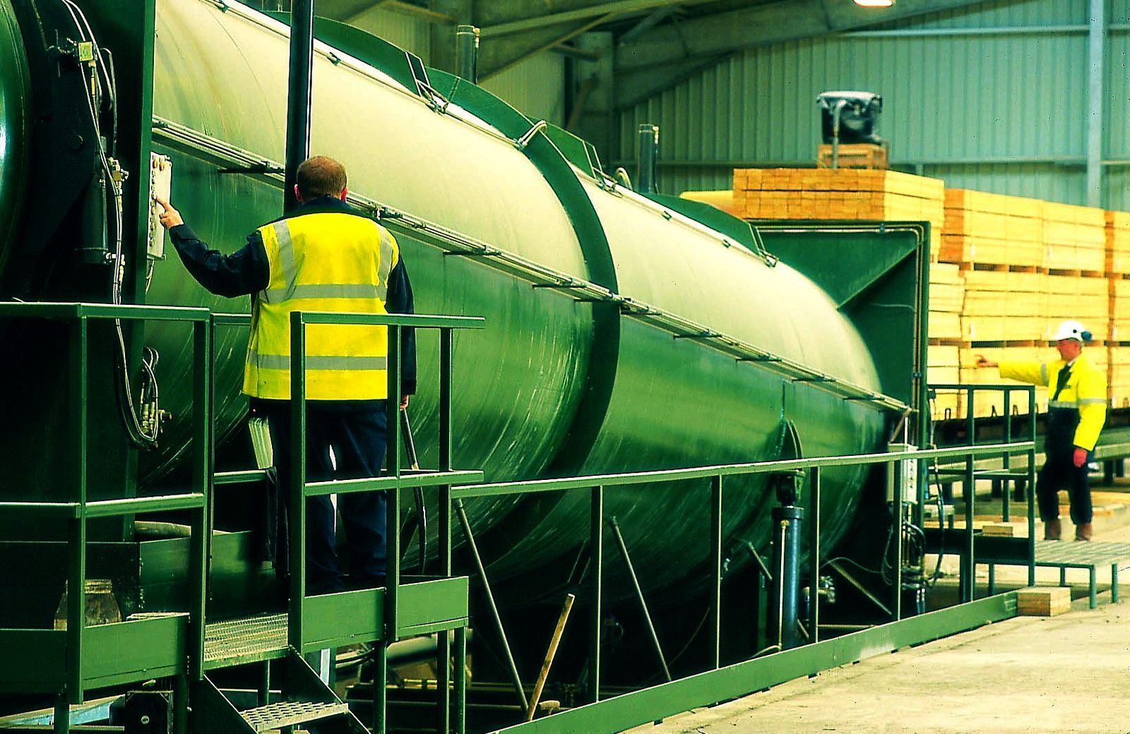 Technicians working alongside a preservative treatment vessel