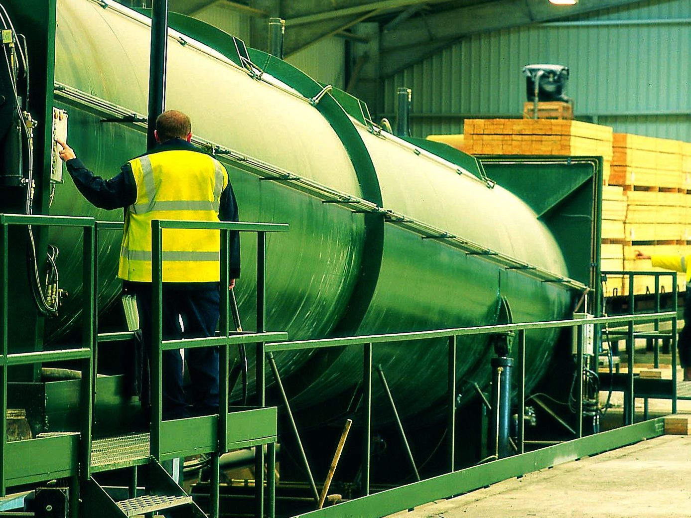 Technicians working alongside a preservative treatment vessel