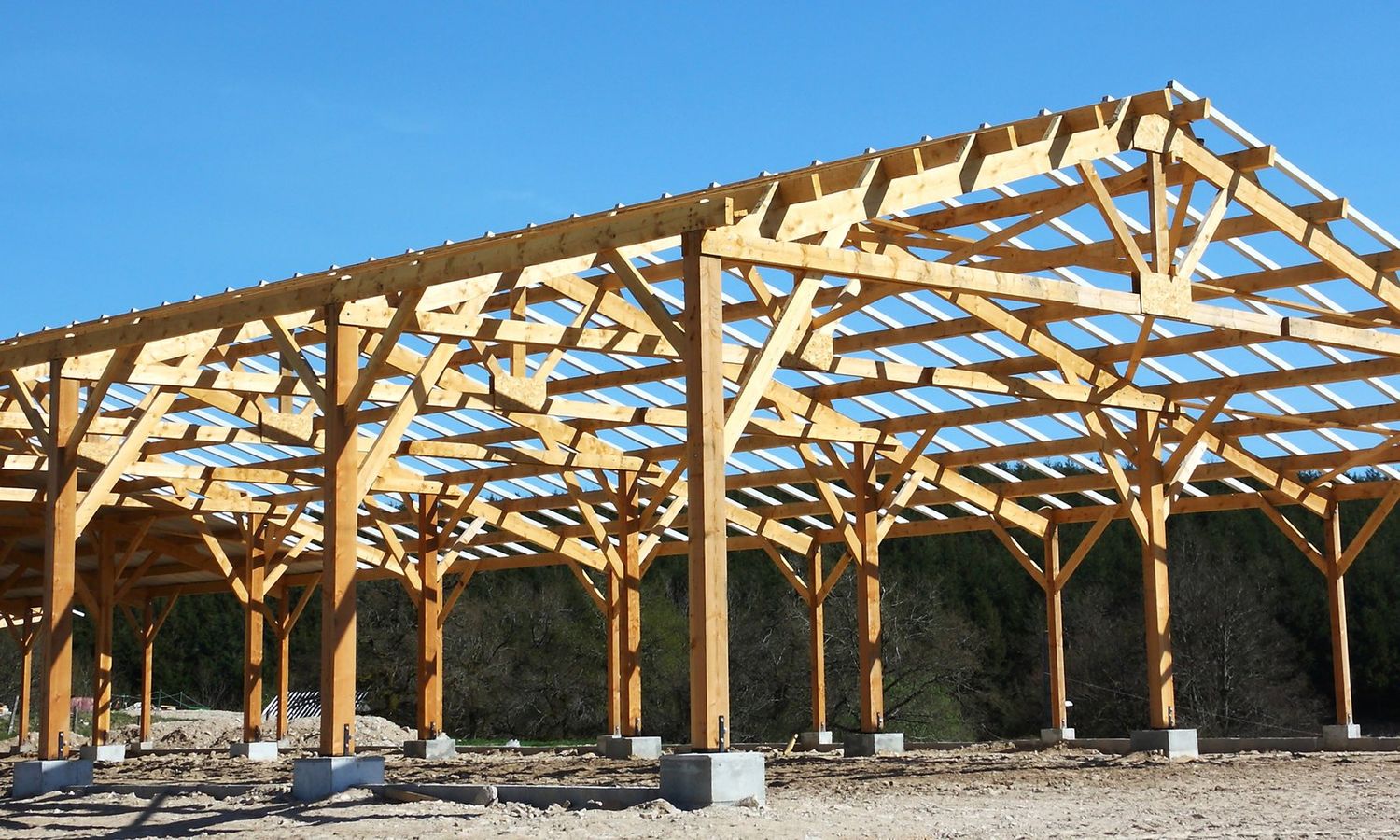 Open timber pole-barn frame under construction