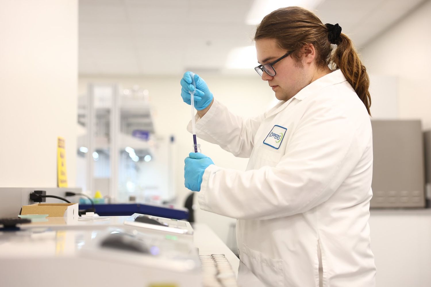 Laboratory technician pipetting a sample into a vial
