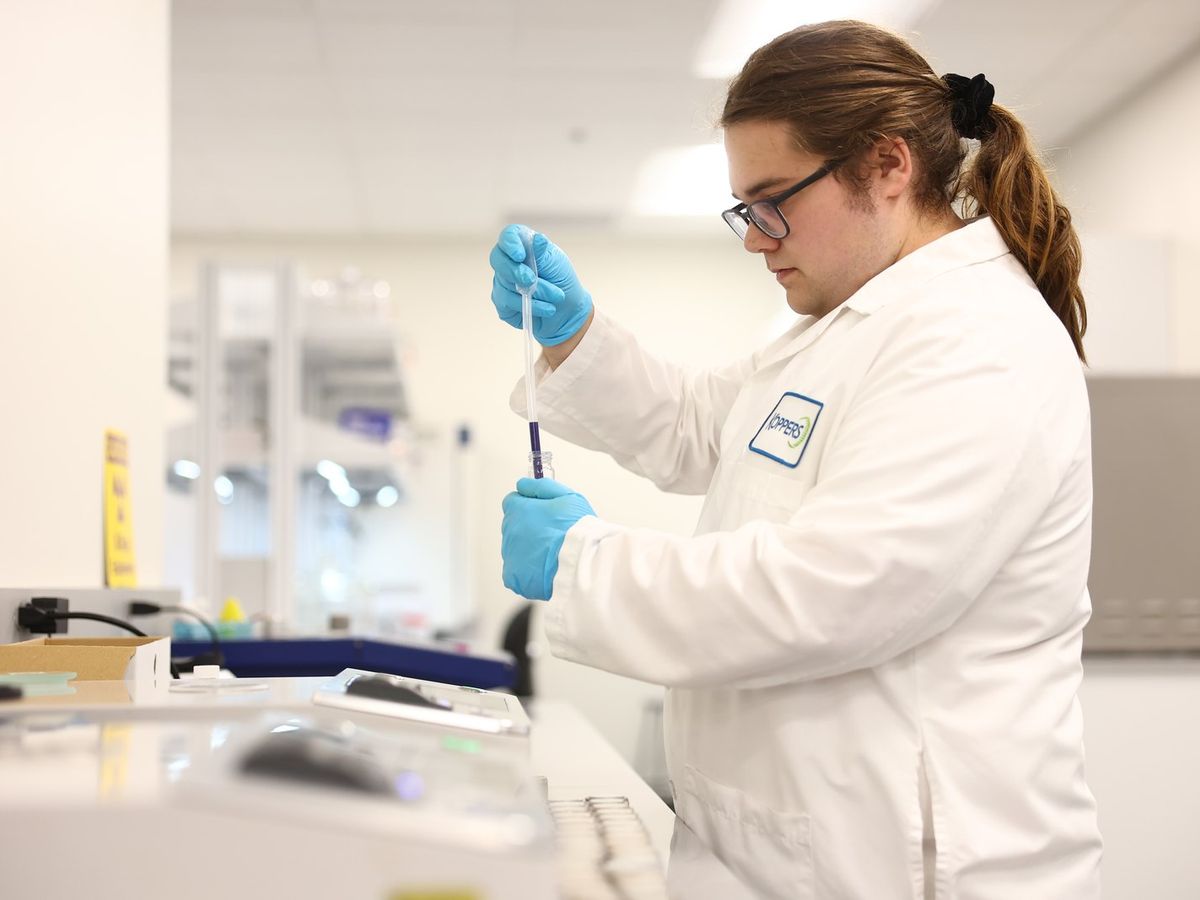 Laboratory technician pipetting a sample into a vial