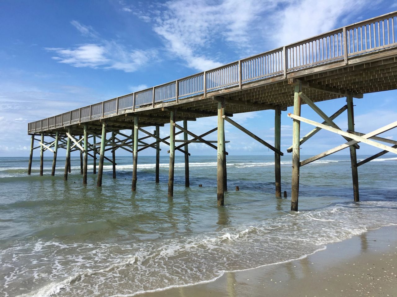 Treated timber pier running out over the surf
