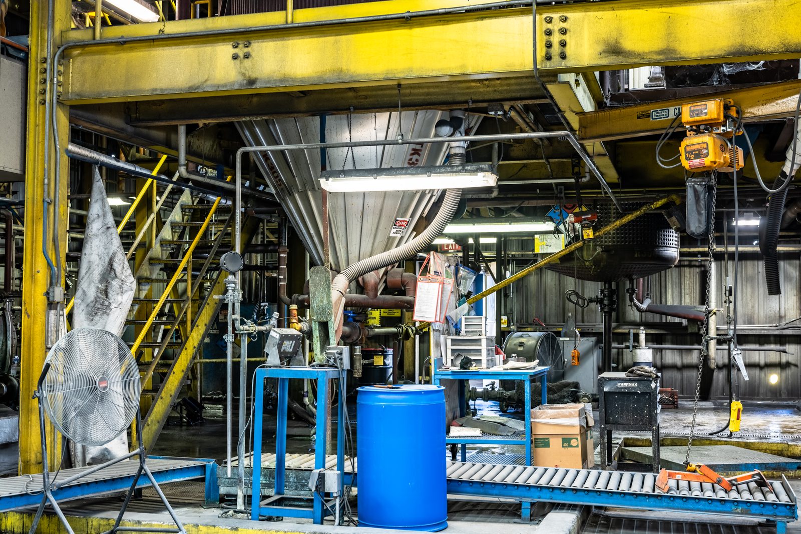 Operator moving material through a preservative plant