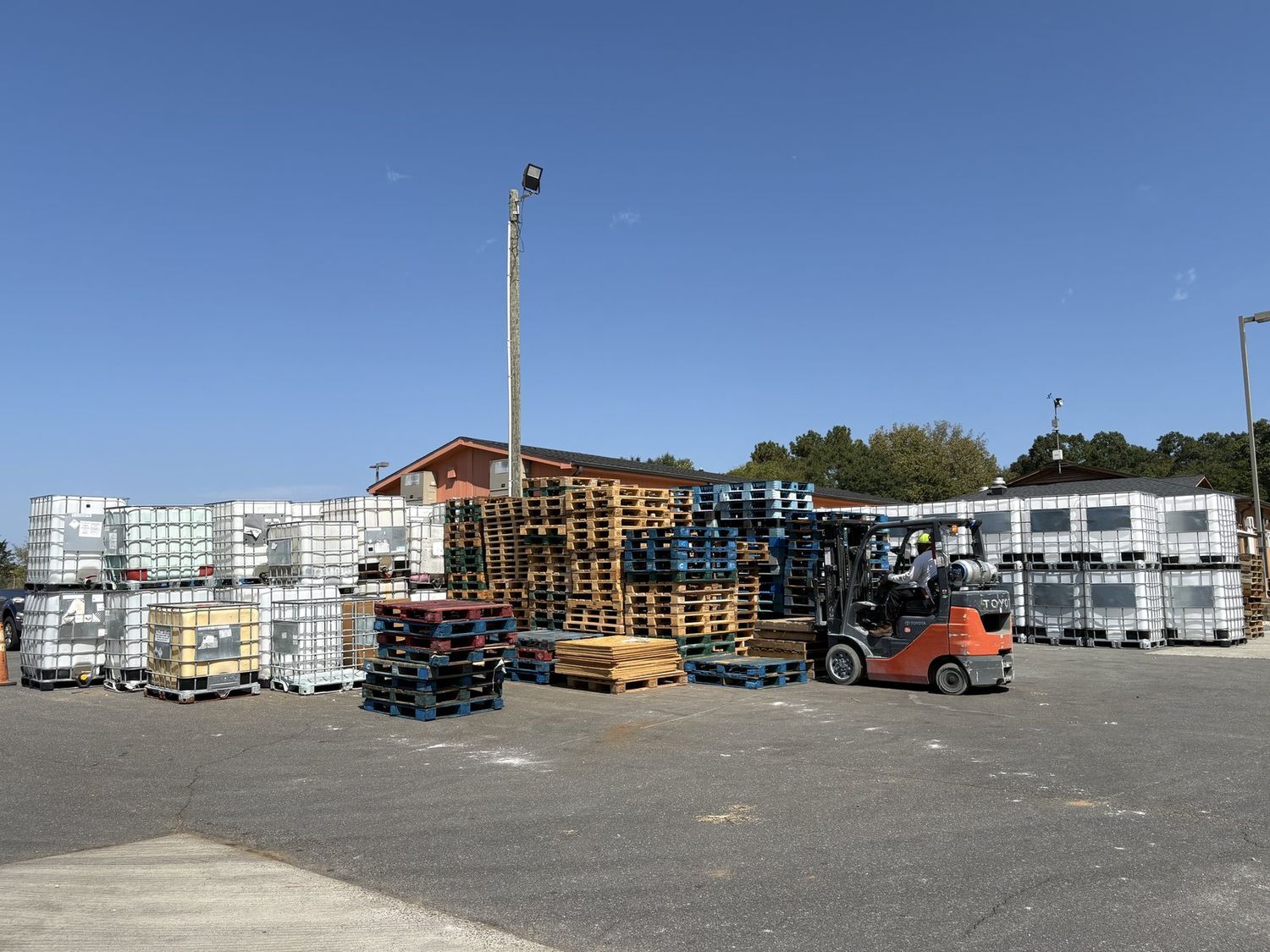 Forklift moving IBC totes in the plant yard