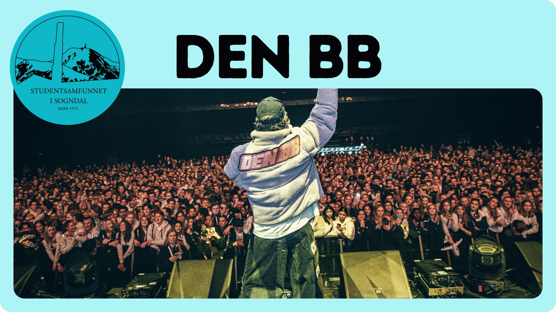 En artist står med ryggen til kameraet og armen i været foran en stor, tettpakket konsertcrowd, med teksten «DEN BB» og logoen til Studentsamfunnet i Sogndal øverst i bildet.