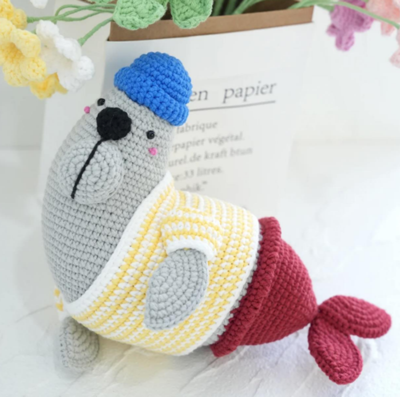 A soft, white fluffy baby seal amigurumi created using this free crochet pattern guide.