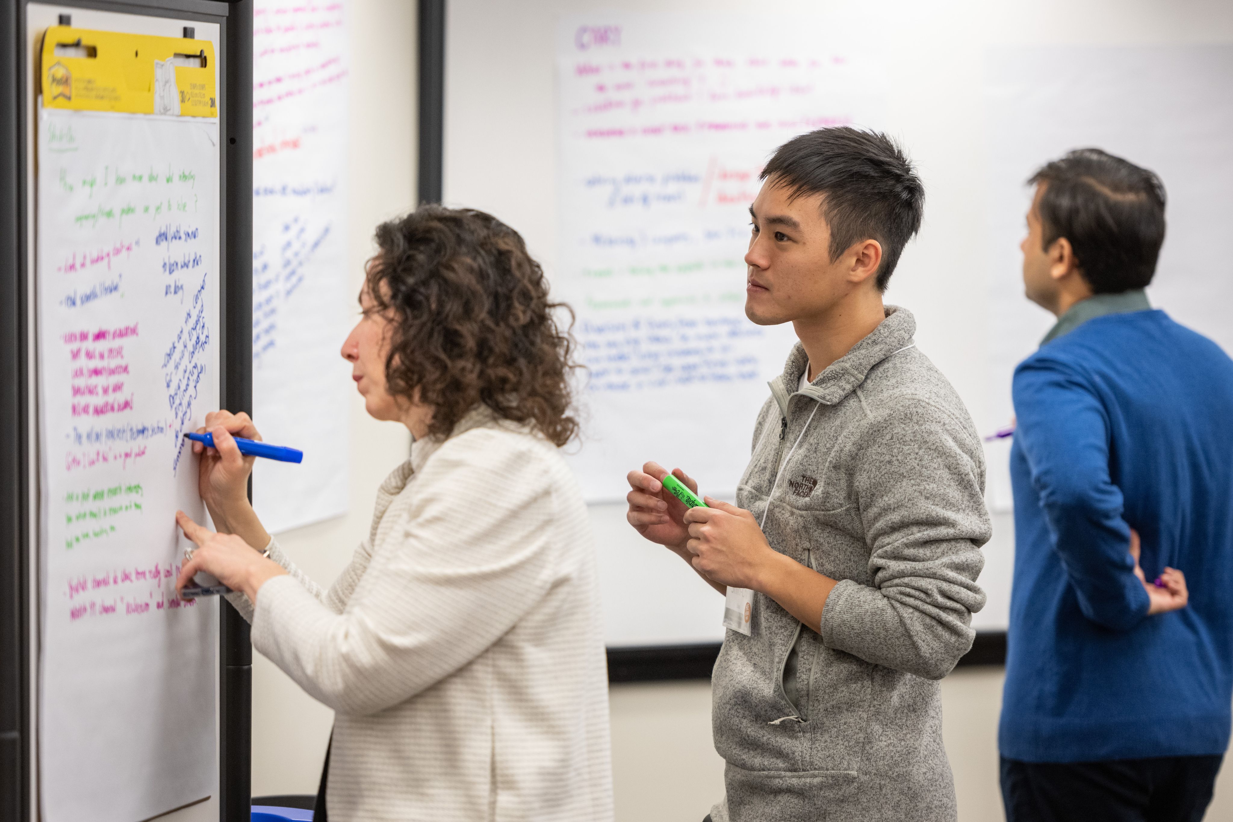 Three people whiteboarding