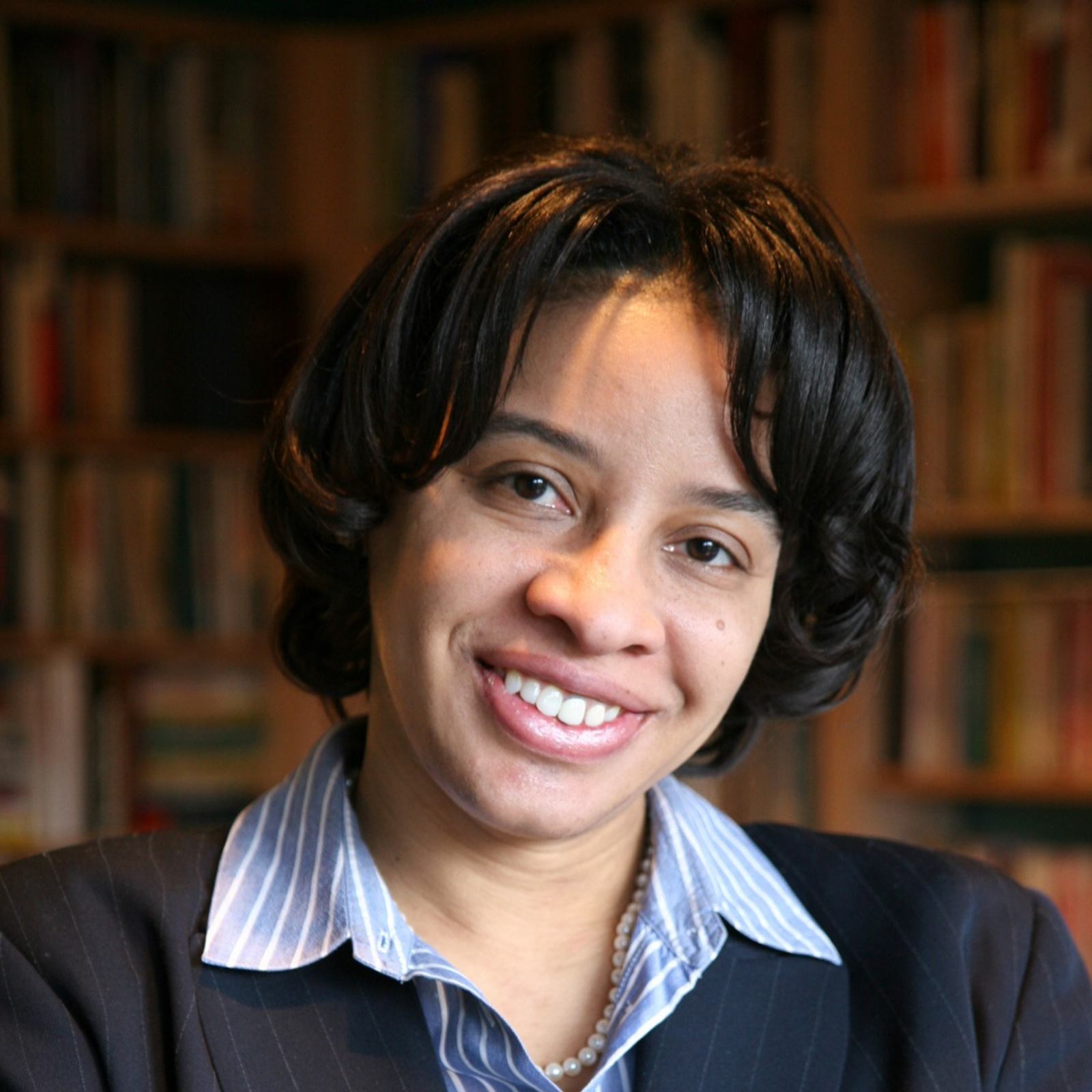 Angela D. Dillard with arms crosses, smiles at the camera