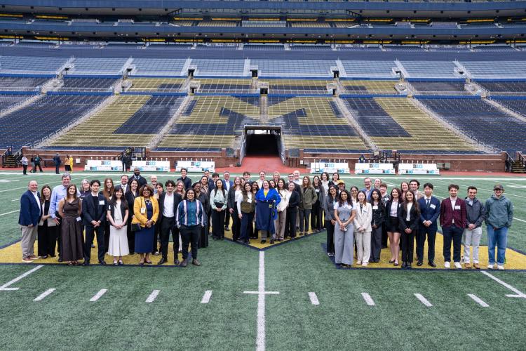 Campus of the Future Student Idea Showcase student finalists and attendees pose for a photo on the Michigan Stadium field.