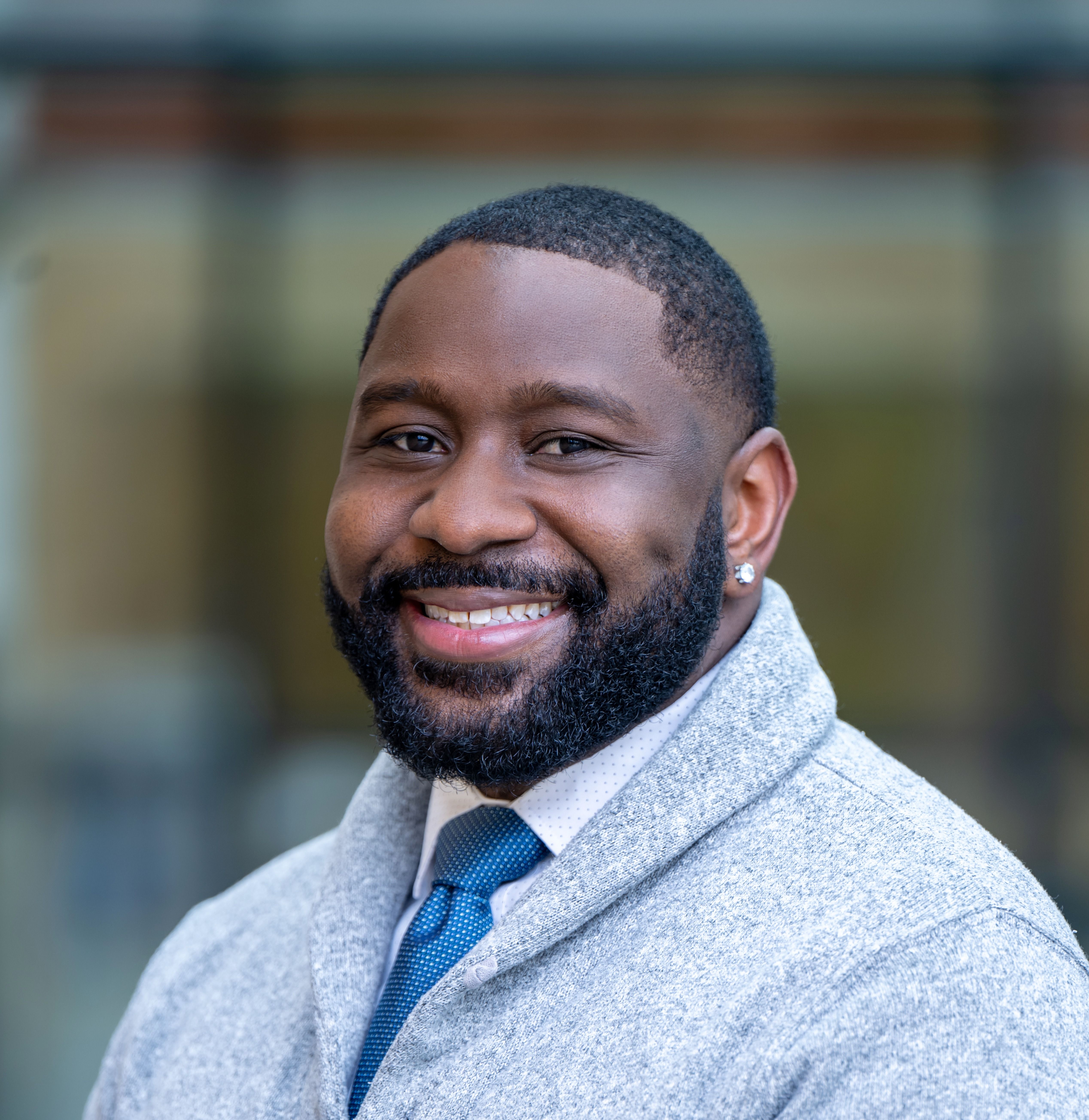 Demetri L. Morgan leans on a railing and smiles at the camera