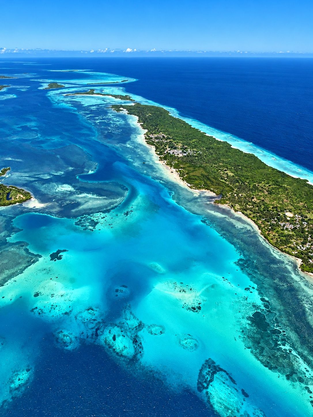 Vista aérea de una isla con arrecifes y aguas turquesa en el Caribe
