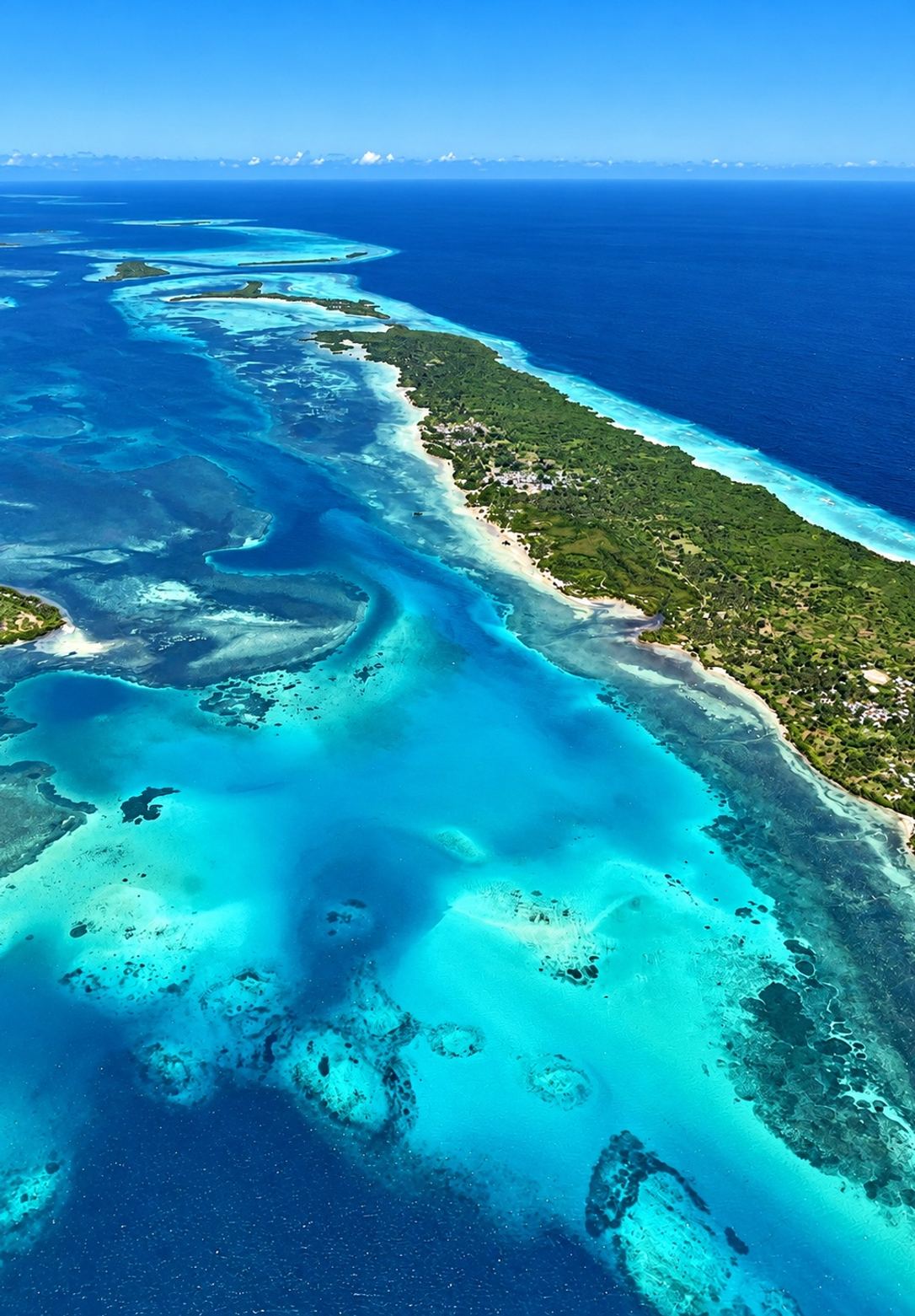 Vista aérea de una isla con arrecifes y aguas turquesa en el Caribe