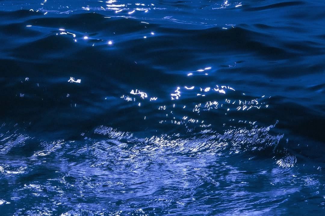 Superficie del mar de noche con reflejos de luz