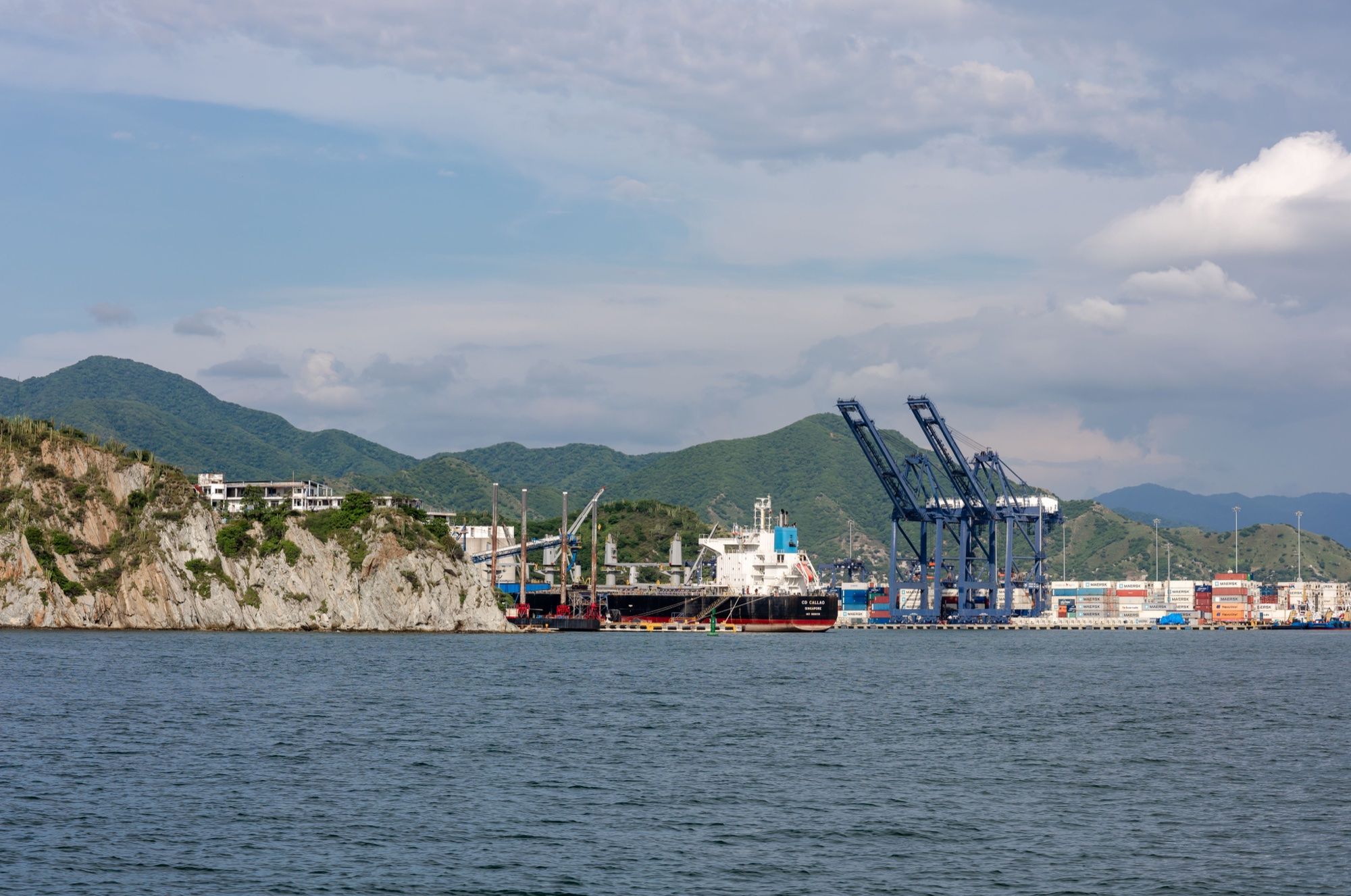 Puerto con grúas de contenedores frente a la costa