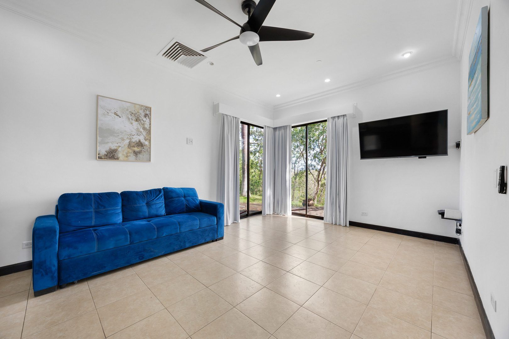 Living room with blue sofa and ceiling fan – Malinche 115B, Reserva Conchal, Guanacaste, Costa Rica